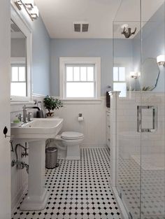 a bathroom with black and white tile flooring and walls, along with a walk in shower