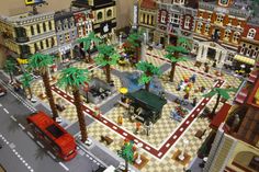 a lego city with palm trees and people on the street in front of buildings that are made out of legos