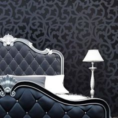 a black and white bedroom with a fancy headboard on the bed, lamp next to it