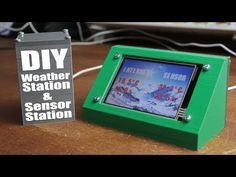 a green wooden frame sitting on top of a table next to a sign that says diy weather station and sensor station