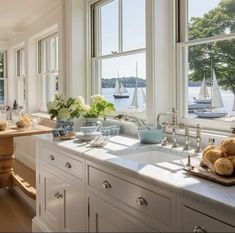 a kitchen filled with lots of counter top space next to a window covered in sailboats