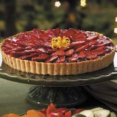 a strawberry pie sitting on top of a cake plate