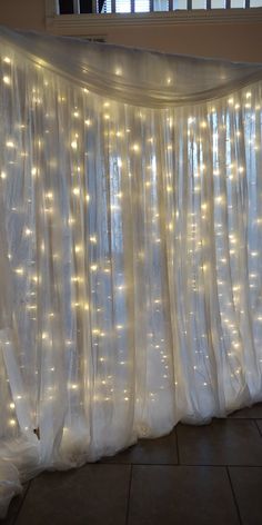 the curtains are covered with lights in front of a window