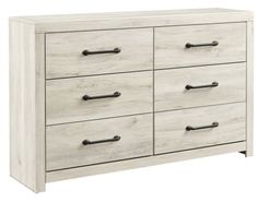 a white dresser with black handles and drawers