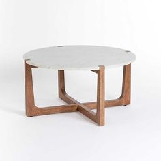 a white marble coffee table with wooden legs