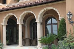 an outdoor courtyard with arches and potted plants