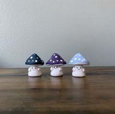 three little mushrooms sitting on top of a wooden table