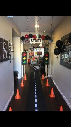 the hallway is decorated with black and white stripes, orange traffic cones, and balloons