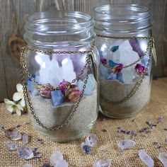 two mason jars filled with sand and flowers