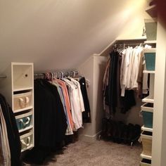 an attic closet with clothes and shoes