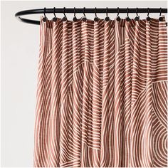 an orange and white striped curtain hanging on a black metal rod, with wavy lines in the background