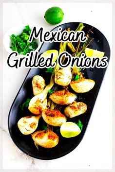 mexican grilled onions on a black platter with limes and cilantro