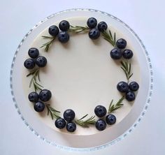 a cake decorated with blueberries and rosemary