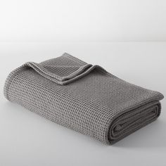 a gray blanket folded on top of a white table