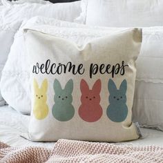 a welcome peeps pillow sitting on top of a bed next to pillows and blankets