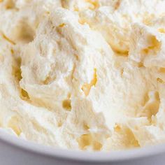 a white bowl filled with whipped cream on top of a table