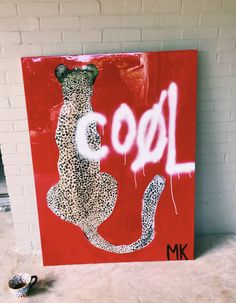 a painting with the word cool painted on it and a pair of shoes next to it