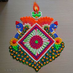 an intricately designed rangolite with peacocks and flowers