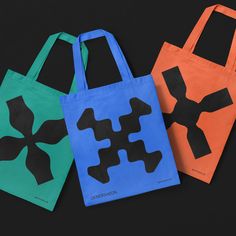 three bags with black and orange designs on them, one is green and the other is blue