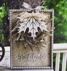 a wooden sign with some leaves on it and the words grateful written in front of it