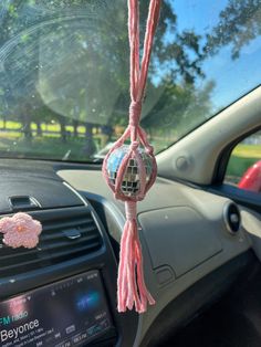 a car dashboard with a pink string hanging from it's center console