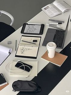 a desk with a laptop, notebook and other office supplies on it's surface