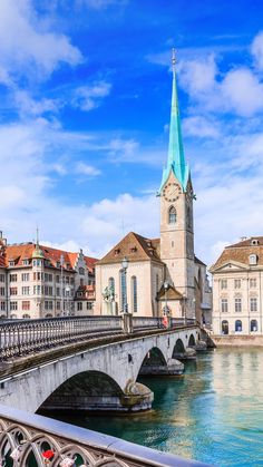 a bridge that has a clock tower in the middle of it and buildings around it