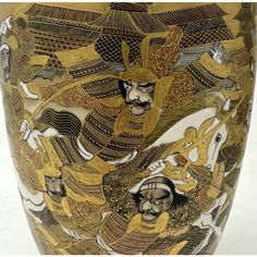 an ornate vase with gold and black designs on the outside, depicting men riding horses