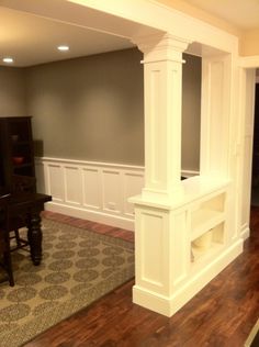 an empty living room with a piano and entertainment center in the corner between two walls