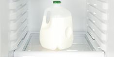 a gallon of milk in an open refrigerator