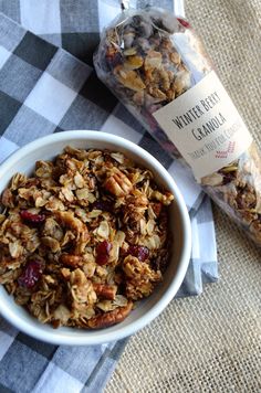 a bowl of granola sitting next to a bag of granola on a table