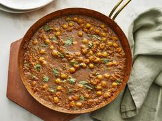 a pan filled with chickpeas and garnished with cilantro leaves