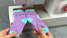 someone is using a sewing machine to sew socks with cats on the bottom and feet