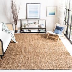 a living room filled with furniture and a large rug on top of a wooden floor