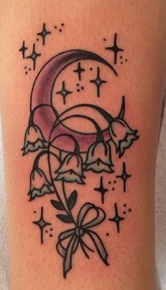 a tattoo on the leg of a woman with a bow and crescent moon in it