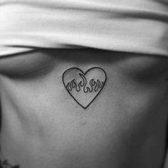 a woman's stomach with the word love written on it and a heart in the middle