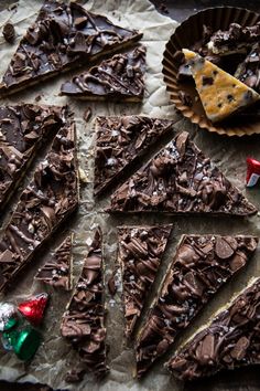 there are many pieces of chocolate cake on the table next to some candy and candies