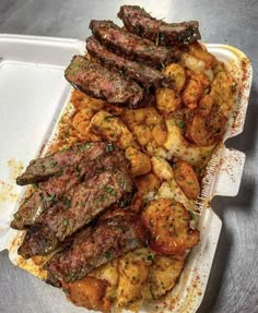 steak and shrimp served in a take out container