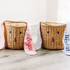 three woven baskets sitting on top of a wooden floor next to each other with ribbon around them