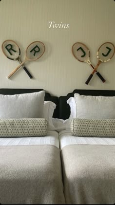 two tennis rackets mounted to the side of a wall next to a pair of beds