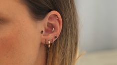 a close up of a person with ear piercings on their ears and wearing earrings