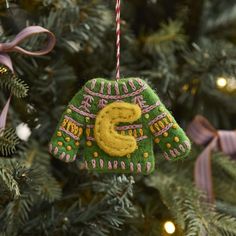 an ornament hanging from the christmas tree with a letter s on it's side