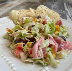 a white plate topped with salad and chips