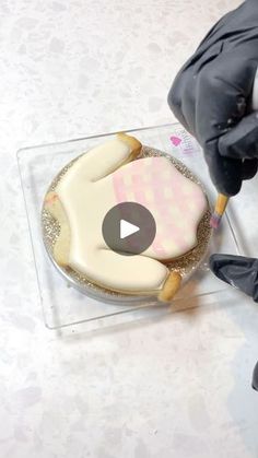 a person in black gloves decorating a cake