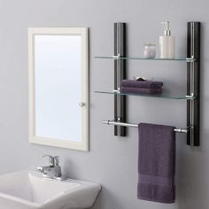 a bathroom with a sink, mirror and towel rack on the wall next to it