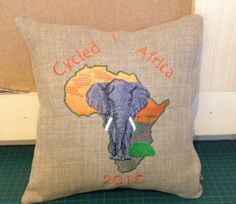 a pillow that has an elephant on it and the words cycled africa written in orange