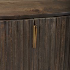 a close up of a wooden cabinet with brass handles