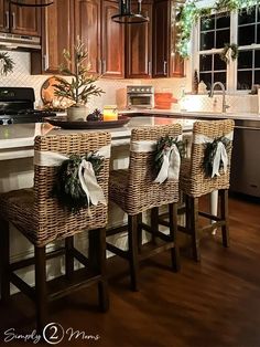 the kitchen is decorated for christmas with wicker barstools and wreaths on them