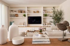 a living room filled with furniture and a flat screen tv mounted on a wall above a fireplace