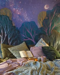 a bed covered in blankets and pillows under a painting on the wall above it is a book